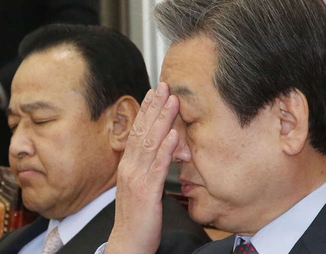 Saenuri Party leader Kim Moo-sung (right) and floor leader Lee Wan-koo attend a government-party consultation meeting to discuss measures to pacify the public’s backlash against its tax policy on Wednesday.   Yonhap