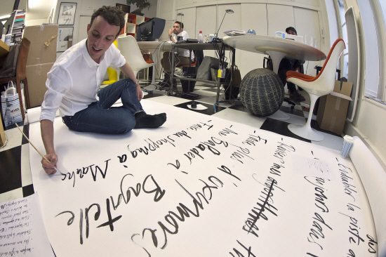 French calligrapher Nicolas Ouchenir works in his studio in Paris on Jan. 14. (AFP-Yonhap)