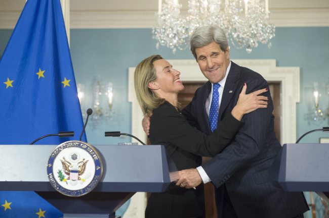 U.S. Secretary of State John Kerry (right) and EU High Representative Federica Mogherini embrace after holding a joint news conference, at the State Department in Washington, D.C., Wednesday.   EPA-Yonhap