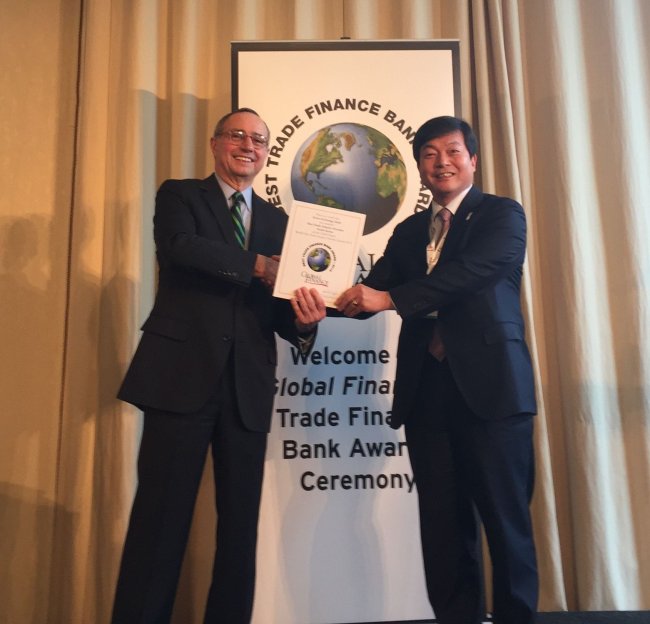 Moon Kwang-chan (right), the head of KEB’s Amsterdam branch, shakes hands with Joseph Giarraputo, the publisher and cofounder of Global Finance, at an award ceremony in Amsterdam on Wednesday.   KEB
