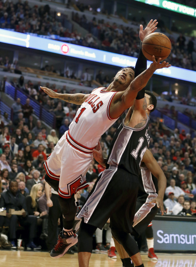Chicago Bulls guard Derrick Rose (left) shoots past San Antonio Spurs guard Danny Green on Thursday.    AP-Yonhap