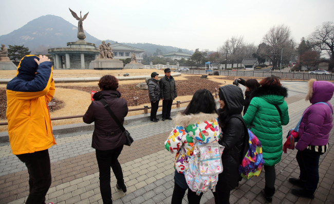 Tourists gather around Cheong Wa Dae in Seoul on Sunday after an anonymous caller threatened to bomb the presidential office.   Yonhap