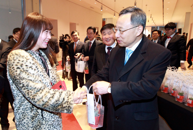 KT CEO and chairman Hwang Chang-gyu (right) hands a flowerpot to an employee to celebrate the opening of the company’s new headquarters building in Gwanghwamun, central Seoul, Monday. KT