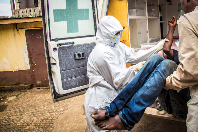 <YONHAP PHOTO-1330> FILE - In this Wednesday, Sept. 24, 2014 file photo, health workers load a suspected Ebola patient into the back of an ambulance in Freetown, Sierra Leone. The World Health Organization is considering reforms that could overhaul its structure in what may be a last-ditch effort to salvage its credibility after botching the response to the biggest-ever Ebola outbreak. WHO has been repeatedly slammed for its sluggish, clumsy efforts in battling the epidemic in West Africa. On Sunday, Jan. 25, 2015, WHO’s executive board, which advises the agency, will discuss proposals that could radically transform the U.N. health agency. (AP Photo/Michael Duff, File)/2015-01-25 19:42:34/ <저작권자 ⓒ 1980-2015 ㈜연합뉴스. 무단 전재 재배포 금지.>
Health workers load a suspected Ebola patient in Freetown, Sierra Leone.   AP-Yonhap
