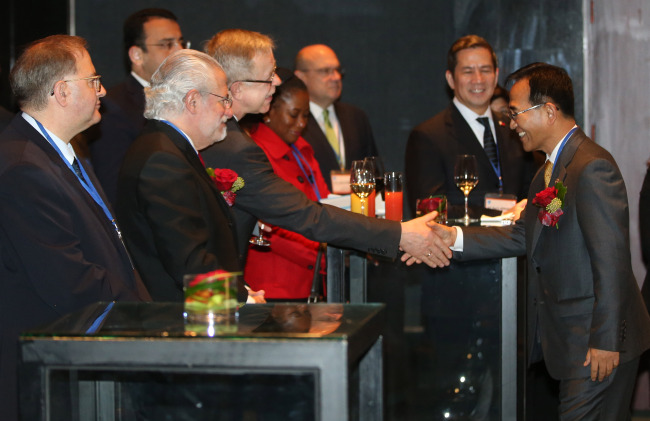 Korea Customs Service Commissioner Kim Nak-hoe (right) shakes hands with foreign ambassadors during the 33rd Annual International Customs Day at a Seoul hotel on Monday.    Yonhap