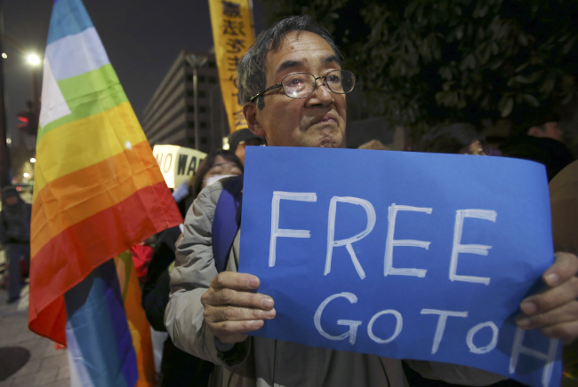 An anti-Prime Minister Shinzo Abe protester attends a rally with a sign in front of Abe’s official residence in Tokyo on Sunday. AP-Yonhap
