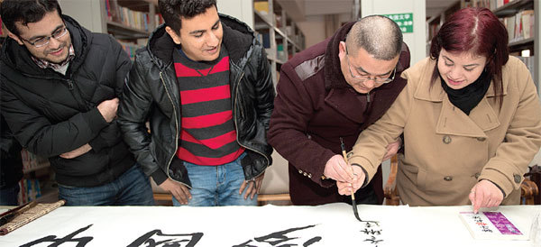 A calligraphy expert shows students how to use a traditional brush pen in Hefei, Anhui province, China, on Jan. 13.   China Daily