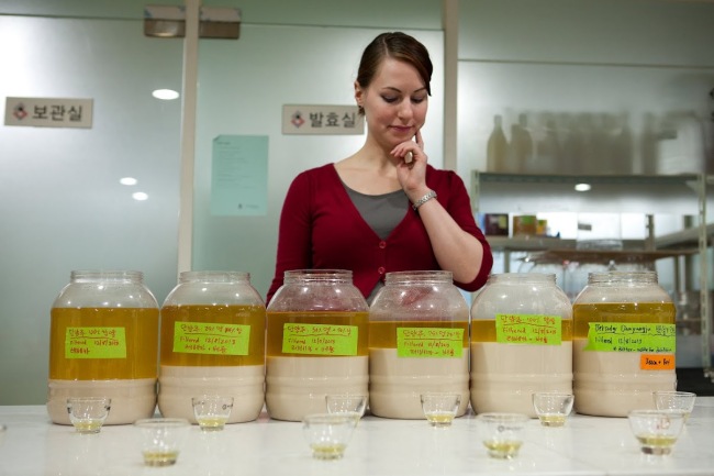 Instructor Becca Baldwin checks a selection of makgeolli brews at Susubori Academy in Seoul. Eun Kyung Kim