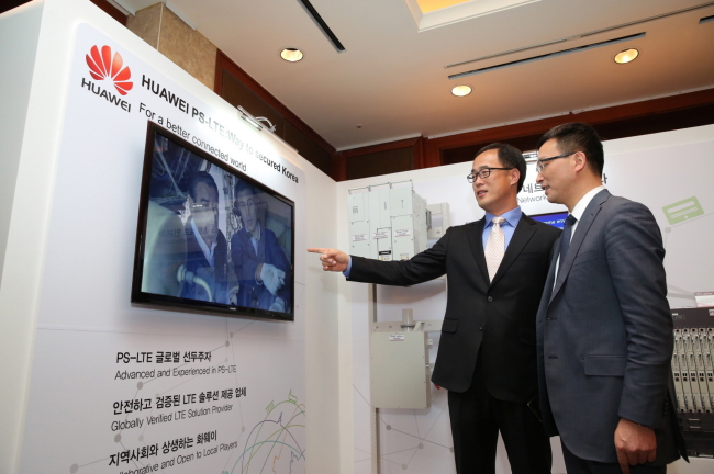 Peter Kim (left), senior executive vice president of Huawei Korea, and Qingwen Wang, Huawei’s vice president of LTE production line, look around the PS-LTE system at a Seoul hotel on Wednesday. Huawei Korea