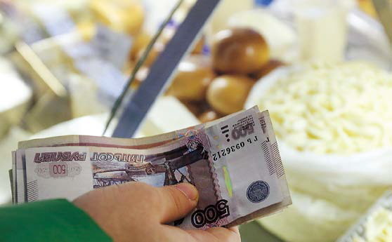 A customer counts out ruble banknotes at a food market in Moscow.
(Bloomberg)