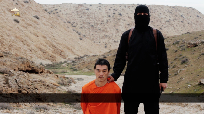 This image made from a video released by Islamic State militants on Saturday, purports to show a militant standing next to Japanese journalist Kenji Goto before his beheading by the militant group.   (AP-Yonhap)