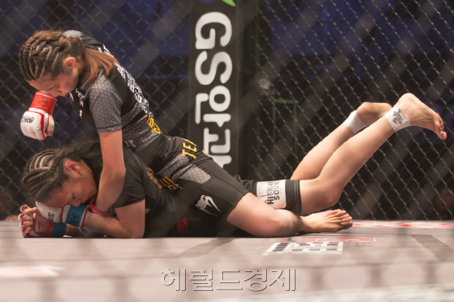 ‘두명의 레게 머리’. 박지혜(위)가 이리에에게 완벽한 백마운트를 점유한 뒤 측두부와 안면에 펀치를 가하고 있다. [사진=정성욱 기자/mr.sungchong@gmail.com]