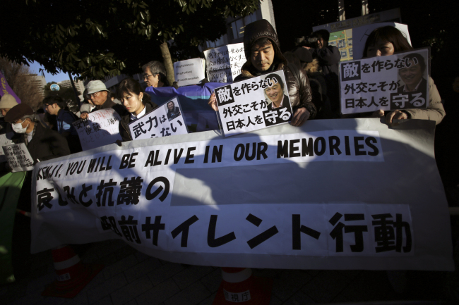 <YONHAP PHOTO-1411> People holding a banner and signs gather to show their sympathy for the killed Japanese hostages, Kenji Goto and Haruna Yukawa, in front of the prime minister's official residence in Tokyo Sunday, Feb. 1, 2015. Appalled and saddened by news Sunday of journalist Goto's beheading, apparently by Islamic State extremists, Japan ordered heightened security precautions, but vowed not to give in to terrorism. The banner reads: "Silent action in sorrow and protest in front of the prime minister's office." The signs read: "We do not need armed forces," left, and "Do no make an enemy. Diplomacy is what protects Japanese people," left and right. (AP Photo/Eugene Hoshiko)/2015-02-01 20:37:58/ <저작권자 ⓒ 1980-2015 ㈜연합뉴스. 무단 전재 재배포 금지.>
People holding a banner and signs gather to show their sympathy for the killed Japanese hostages, Kenji Goto and Haruna Yukawa, in front of the prime minister’s official residence in Tokyo on Sunday.    AP-Yonhap