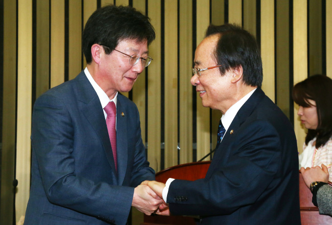 The Saenuri Party’s new floor leader Rep. Yoo Seong-min (left) shakes hands with rival candidate Rep. Lee Ju-young after winning the election on Monday at the National Assembly.   Lee Gil-dong/The Korea Herald