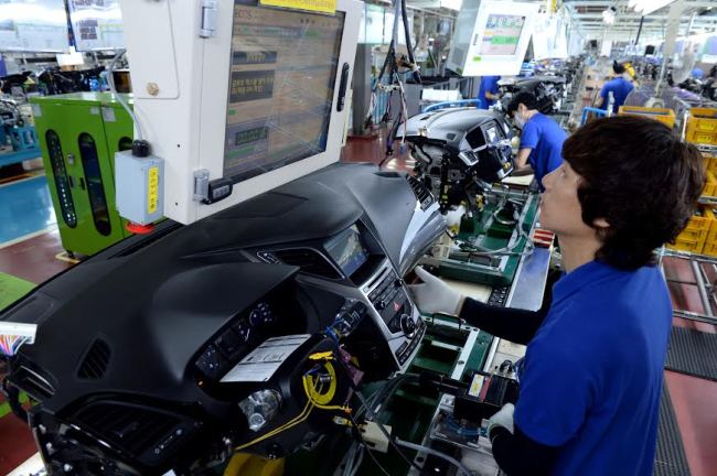 A worker assembles a cockpit module while monitoring the production progress at the Hyundai Mobis Asan plant in South Chungcheong Province. Hyundai Mobis
