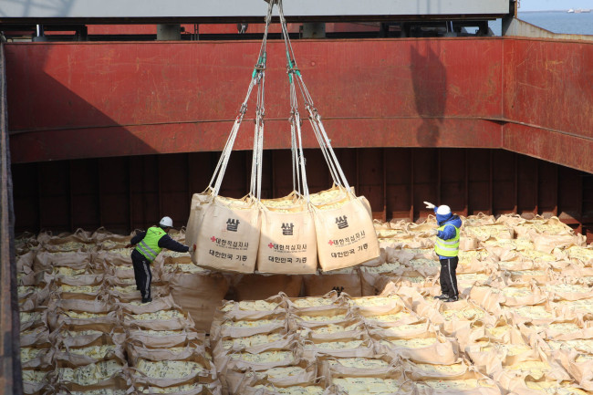 South Korean workers stack bags of rice.   Yonhap