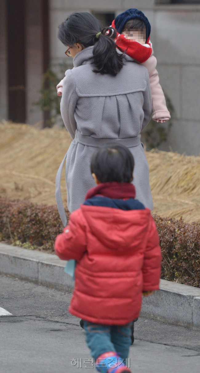 대한민국 워킹맘은 고단하다. 직장 퇴근 후에는 또다시 집으로 출근해야하는 우리나라 워킹맘의 주당 평균 근무시간은 70시간이다. 남편보다 13시간 더 일하는 셈이다. 한 워킹맘이 출근길에 아이들을 어린이집에 데려다 주고 있다.  [김명섭 기자 msiron@heraldcorp.com]