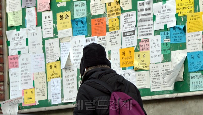 대학생들이 천정부지로 치솟는 월세비용과 하숙집 주인의 갑질에 시달리고 있다. 지방에서 수도권으로 상경해 원룸에서 거주하는 대학생들은 1400만원이 넘는 보증금에 매달 42만원 가량의 월세를 지출하고 있다는 조사결과도 나왔다. 한 대학생이 서울 중앙대 대로변에 빼곡히 붙어 있는 원룸, 자취방, 하숙집 벽보를 유심히 살피고 있다. [김명섭 기자/msiron@heraldcorp.com]