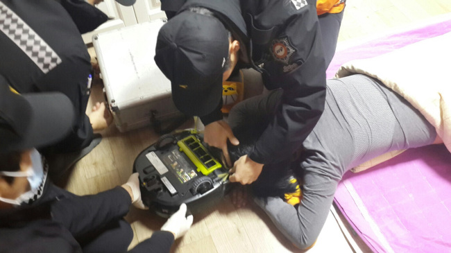 <YONHAP PHOTO-0995> 로봇청소기에 머리카락 빨려 들어가…출동 119 '진땀' (창원=연합뉴스) 창원소방본부 마산소방서가 지난 3일 오후 8시43분 경남 창원시 마산합포구 모 주택에서 로봇청소기에 머리카락이 빨려 들어가 구조를 요청한 50대 여성을 구조하고 있다. 긴급 출동한 119구조대는 청소기를 완전히 분리 해제한 뒤 기계에 낀 이 여성의 머리카락을 안전하게 빼냈다. 이 여성은 머리카락 10여개가 뽑혔지만 일상생활에 안전하게 복귀했다. 2015.2.4 choi21@yna.co.kr/2015-02-04 13:52:31/ <저작권자 ⓒ 1980-2015 ㈜연합뉴스. 무단 전재 재배포 금지.>
A rescue team saves a woman whose hair was sucked into a robot vacuum while she was sleeping in Changwon, South Gyeongsang Province, Tuesday.   Yonhap