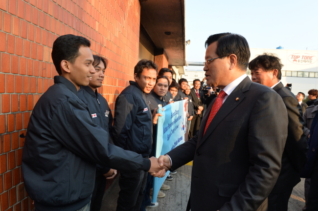 National Assembly Speaker Rep. Chung Ui-hwa (right) shakes hands with an Indonesian laborer in Ansan, Gyeonggi Province, Thursday.   The National Assembly