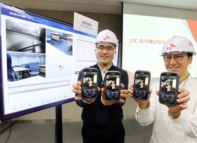 SK Telecom officials pose with gadgets running on the firm’s emergency network system based on Long Term Evolution technology during a media briefing in Seoul on Wednesday.   SK Telecom