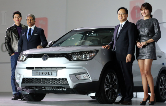 Mahindra Group chairman Anand Mahindra (second from left) poses next to the newly launched compact SUV, jointly developed by the group’s Korean arm Ssangyong Motor, with other company officials at a launch in Seoul on Jan. 13.   Yonhap