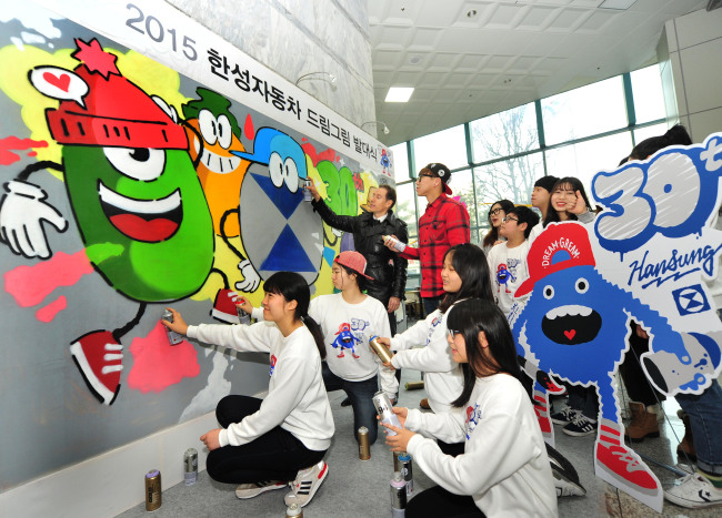 Han Sung Motor CEO Ulf Ausprung and teenage students paint a mural sponsored by the Dream Gream project in Seoul on Feb 5.   Han Sung Motor