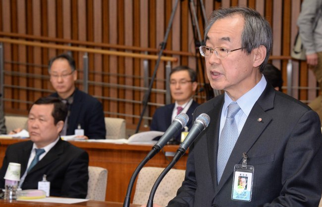 Suh Moon-kyu, president of the Korea National Oil Corp., reads reports to parliamentary committee members on overseas energy investments by state-controlled firms at the National Assembly in Seoul, Thursday.   Lee Gil-dong/The Korea Herald