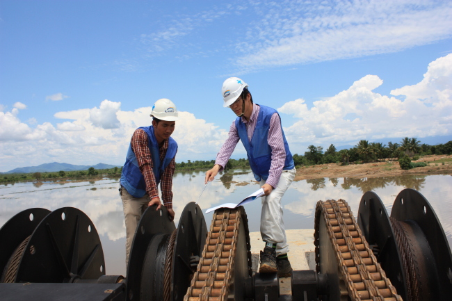 Two K-water employees check a dam in Krang Ponley, Cambodia.   K-water