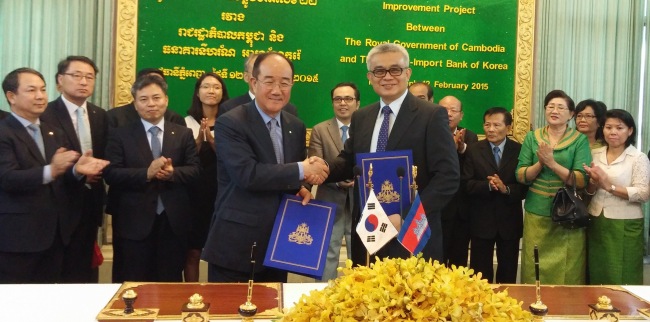 Eximbank chairman Lee Duk-hoon (left) shakes hands with Cambodian Finance Minister Aun Porn Moniroth after signing a loan contract in Phnom Penh on Thursday.   Eximbank
