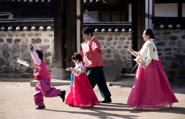 A family flies kites on a Lunar New Year holiday at Namsangol Hanok Village in Seoul.   Korea Tourism Organization