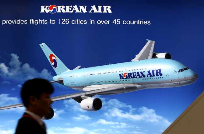 A visitor walks past a Korean Air advertisement at an exhibition in Goyang, Gyeonggi Province, Oct. 29, 2013.   Bloomberg