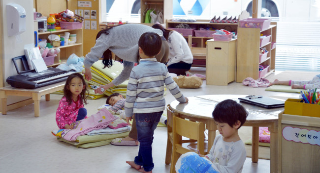 23일 서울 관악구에 위치한 서울대 느티나무 어린이집의 보육교사 박모(26ㆍ여) 씨가 아이들을 챙겨주고 있다.