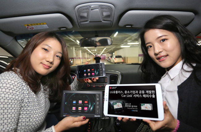LG Uplus officials pose with the smartphone mirroring solution for automobiles, Car Link, in Seoul on Monday.   LG Uplus