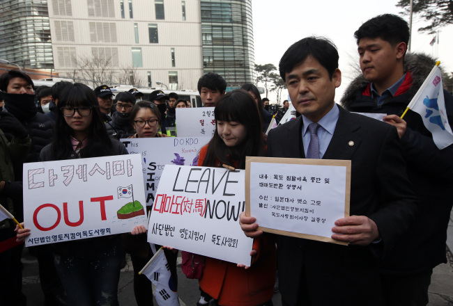 Members of a civic group campaigning for the safeguarding of Dokdo march toward the Japanese Embassy in Seoul on Monday to deliver a written complaint about a local ceremony in Japan on Sunday that repeated its claim to the islets.   Yonhap