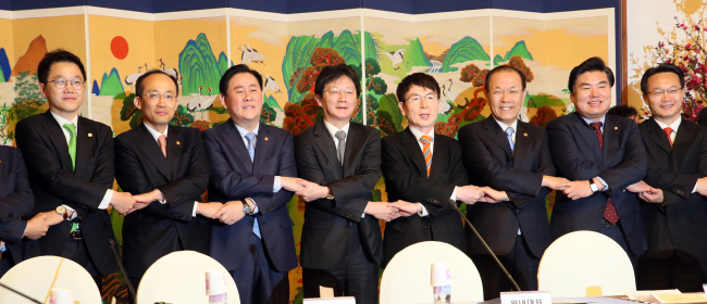 From left: Government Policy Coordination Minister Choo Kyung-ho, Finance Minister Choi Kyung-hwan, Saenuri floor leader Rep. Yoo Seung-min, Presidential Senior Secretary for Policy Coordination Hyun Jung-taik, Education Minister Hwang Woo-yea, Saenuri Policy Committee Chairman Won Yoo-chul and deputy floor leader Cho Hae-jin hold hands for a photo at a meeting of the newly launched trilateral committee on policy coordination on Wednesday.   Yonhap