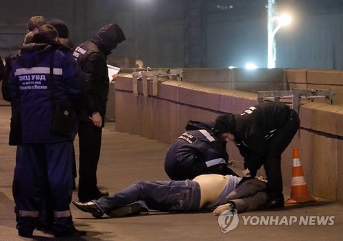 Russian police look at the body of Boris Nemtsov, a former Russian deputy prime minister and opposition leader, at Red Square in Moscow on Feb. 28, 2015. /AP