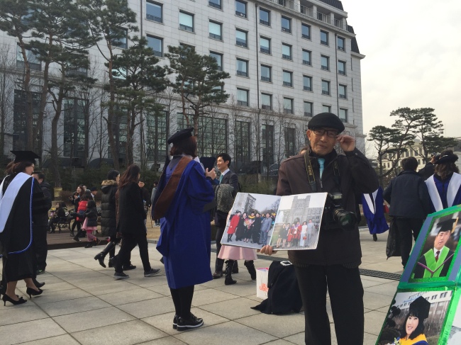 전문사진사 김일만(78ㆍ가명)씨가 지난달 25일 졸업식이 열린 서울의 모 여대에서 사진 판넬을 들고 포즈를 취하고 있다.