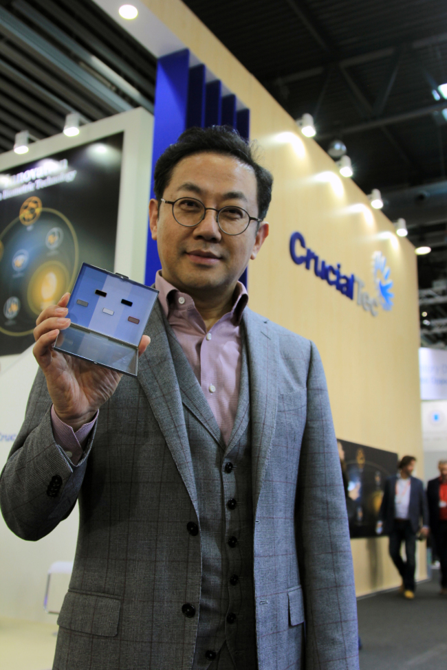 CrucialTec CEO Charles Ahn poses with fingerprint modules at the MWC on Monday.