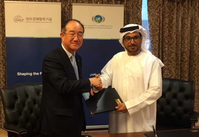 Lee Duk-hoon (left), president of the state-run Export-Import Bank of Korea, shakes hands with Mohammed Saif Al Suwaidi, secretary-general of Abu Dhabi Fund for Development, on Thursday. The two organizations signed a memorandum of understanding to share experience on public-private partnership and cofinance projects in developing countries.   Korea Eximbank