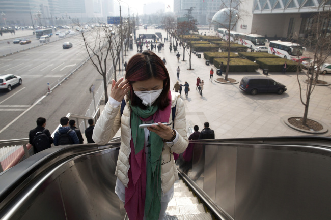 A woman wears a mask during a day of heavy pollution in Beijing on Saturday.   AP-Yonhap