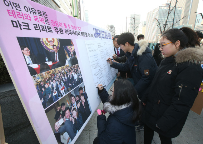 <YONHAP PHOTO-0566> '리퍼트 대사 쾌유 기원' (서울=연합뉴스) 서명곤 기자 = 7일 오전 서울 광화문 미국대사관 인근 인도에 북한민주화청년학생포럼이 마크 리퍼트 주한미국대사의 쾌유를 기원하기 위해 설치한 게시판에 고등학생들이 글을 남기고 있다. 2015.3.7 seephoto@yna.co.kr/2015-03-07 13:01:26/ <저작권자 ⓒ 1980-2015 ㈜연합뉴스. 무단 전재 재배포 금지.>
Korean high school students leave comments on a board near the U. S. Embassy on Saturday, wishing U.S. Ambassador Mark Lippert a speedy recovery.   Yonhap