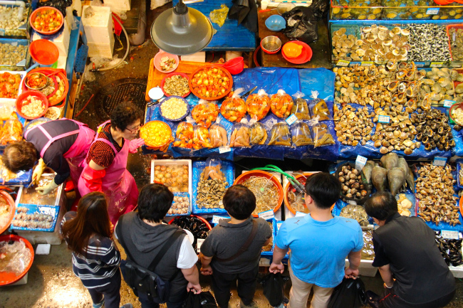 Visitors gaze at the array of seafood on sale at the Noryangjin Fisheries Wholesale Market in Dongjak-gu, Seoul.   Julie Jackson/The Korea Herald