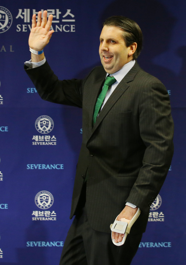 U.S. Ambassador to Korea Mark Lippert waves as he enters a press conference before being discharged from Yonsei Severance Hospital on Tuesday. Yonhap