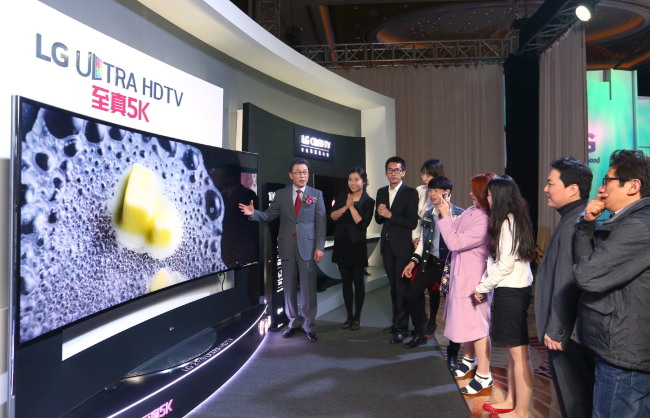 LG Electronics’ China chief and president Shin Moon-beom (left) describes the company’s new ultra-HD TV to journalists during the LG InnoFest held in Shanghai on Wednesday.   LG Electronics