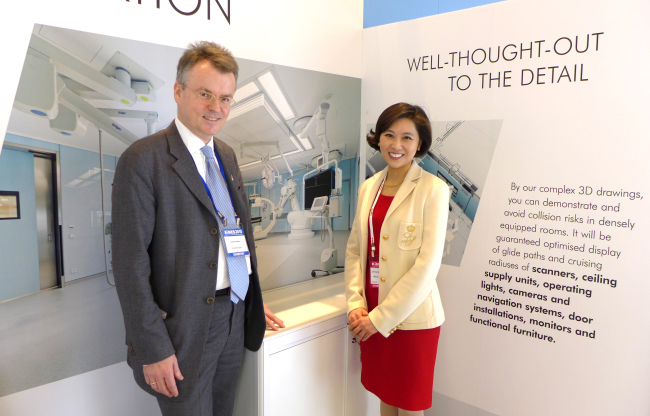 Deputy Head of Mission of the German Embassy Theodor Schuster (left) poses with Samsung Medical Center’s clinical assistant professor Alice Tan in front of Labor Hospitaltechnik’s booth at the 2015 Korea International Medical and Hospital Equipment Show at Coex on March 6.   Joel Lee/The Korea Herald