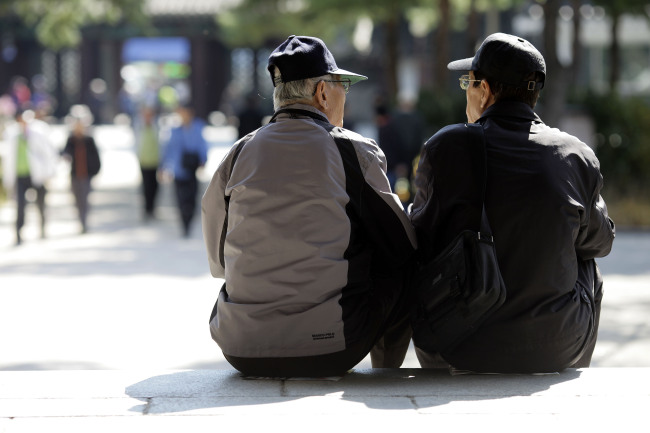 Elderly men sit on steps at Tapgol Park in Jongno district, Seoul.   Bloomberg