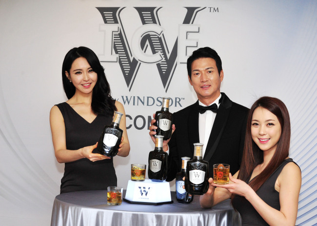 Cho Kil-soo (center), CEO of global whiskey-maker Diageo Korea, promotes “W Ice by Windsor,” the company’s new low alcohol-content whiskey brand, at a launch in Seoul on Wednesday.   Diageo Korea