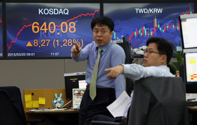 KEB employees gesture in their dealing room as KOSDAQ broke the 640 mark for the first time in 81 months on Friday . The tech-heavy exchange rose 8.27 points, or 1.31 percent, to close at 640.08.  Yonhap