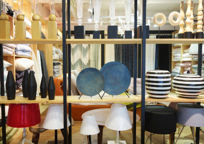 Korean scented candles and home decor objects arranged on a cozy interior shelf showing K-lifestyle goods